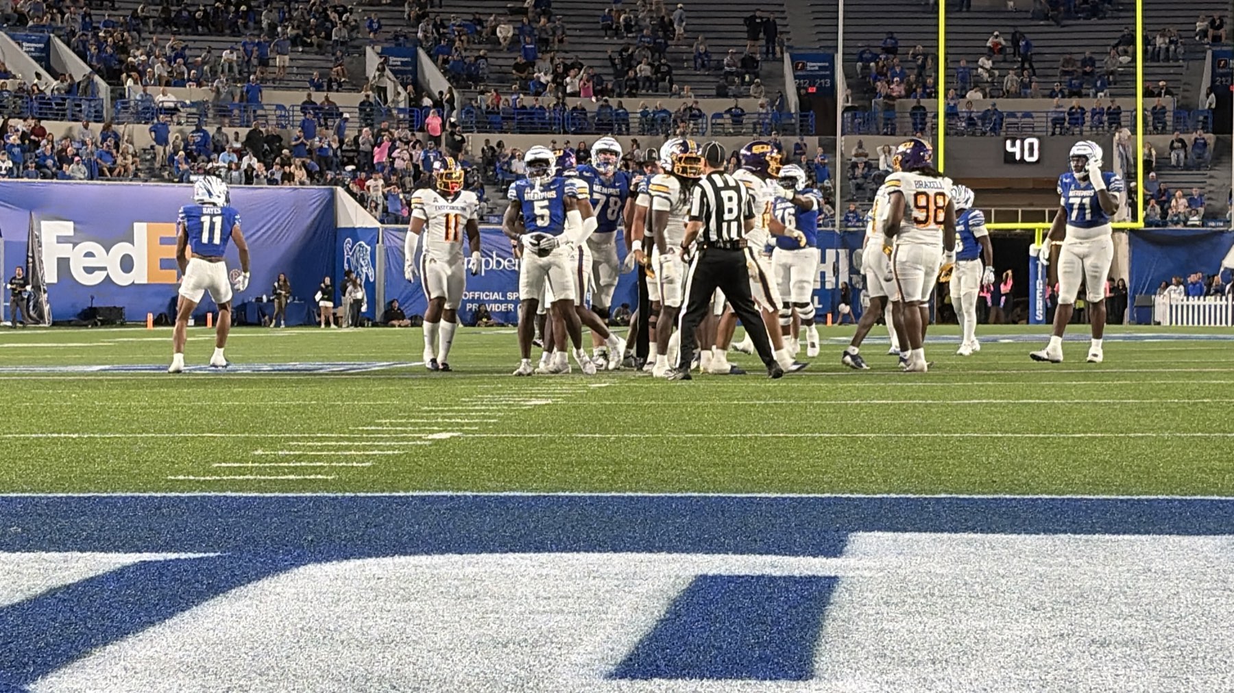 Memphis and East Carolina players on the field between plays